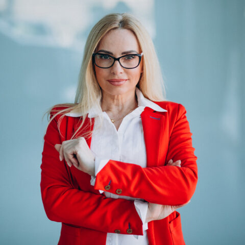 Business woman in red jacket isolated in office